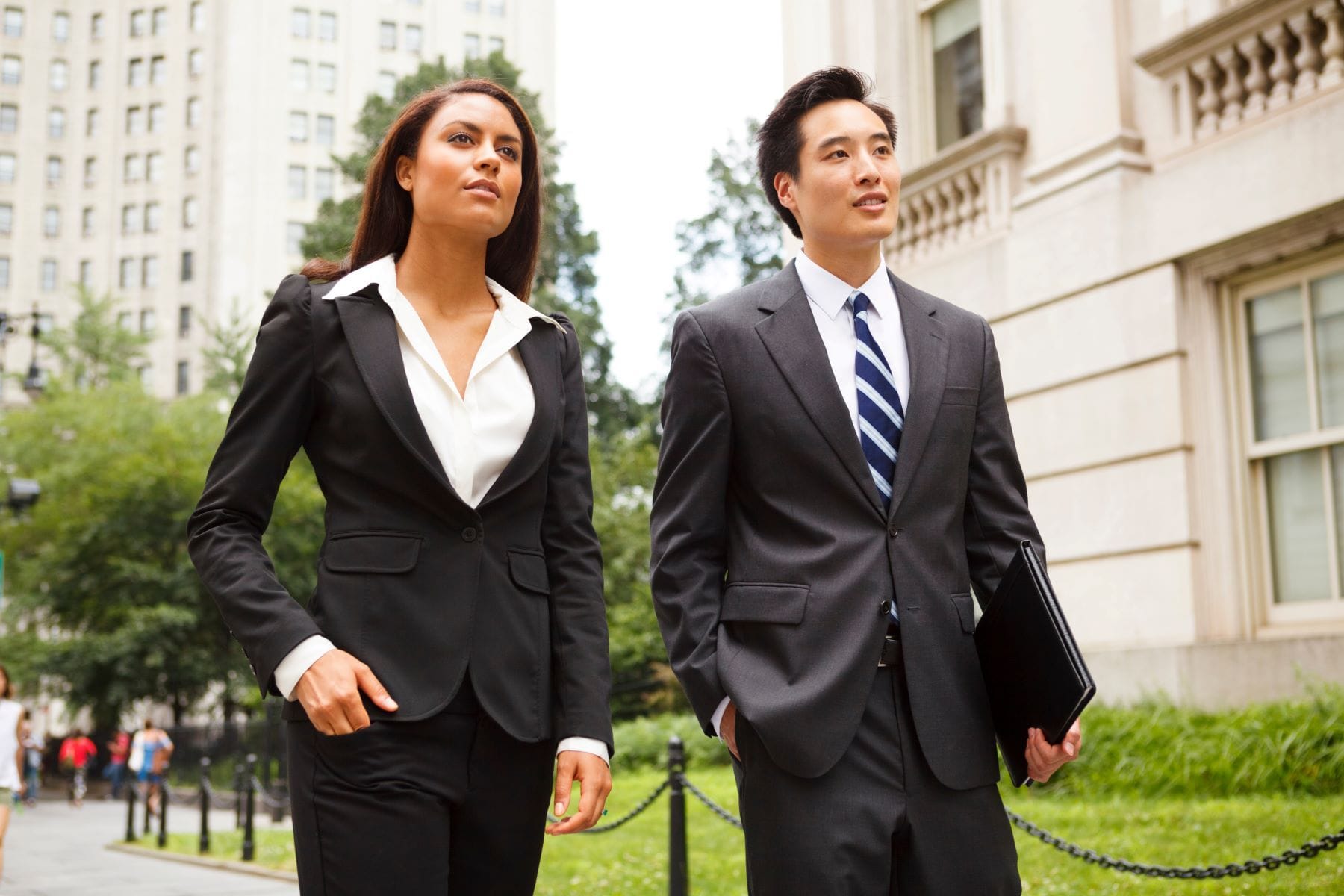 Two well dressed professionals walking down a city street