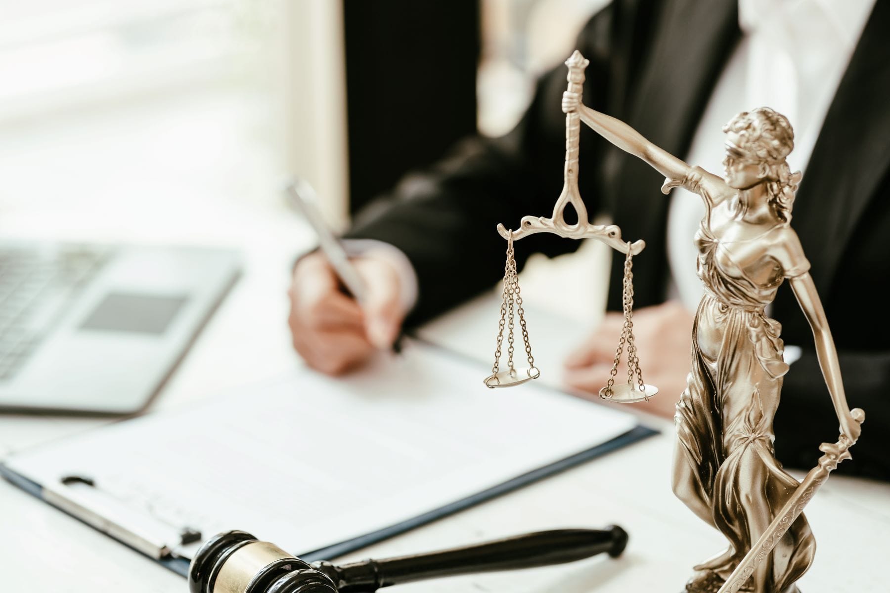 Attorney working at desk with gavel and scales of justice