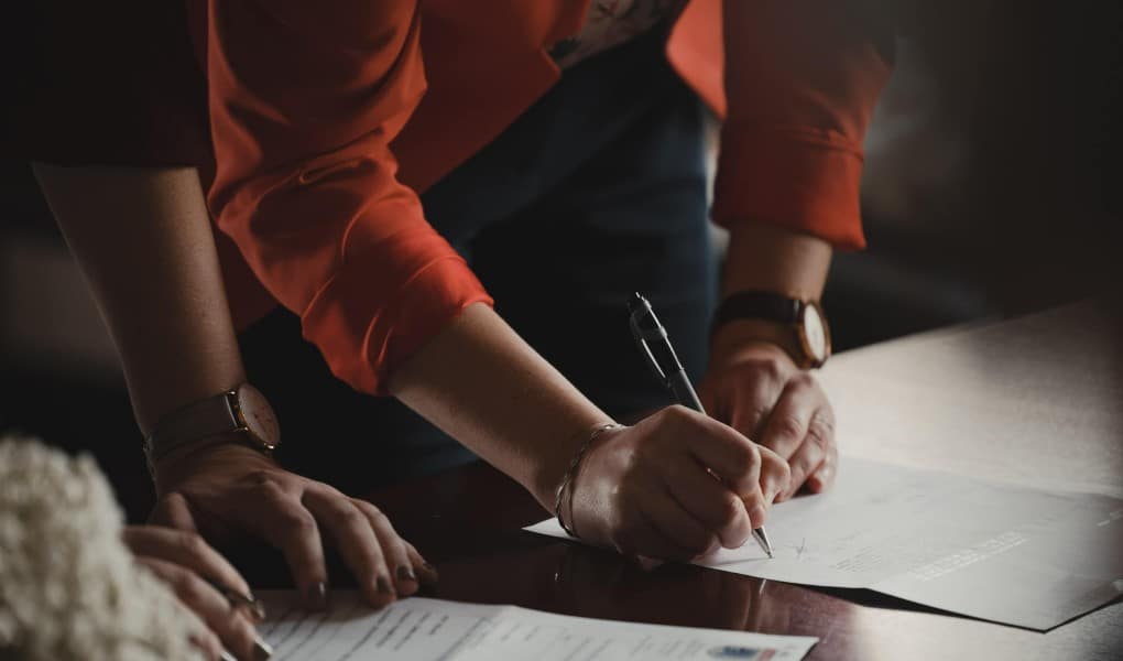 two people signing papers